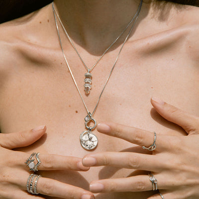 A woman wearing the Awe Inspired Artemis Pendant and ring.