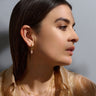 Model wearing a single Crystal Quartz Huggie Earring in gold vermeil
