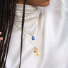 Model wearing Indigo Aura amulet with a blue sapphire gemstone in gold vermeil