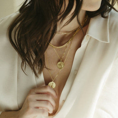 A woman wearing a white shirt and Awe Inspired Mulan Pendant necklaces.