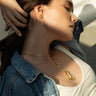 A woman wearing a denim jacket and an Awe Inspired Crystal Quartz Amulet necklace.
