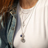 A woman wearing an Awe Inspired Lapis Lazuli Scarab Amulet necklace with several charms.