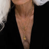 A woman with white hair wearing a Awe Inspired Cross Amulet necklace.