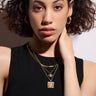A woman wearing a black top and Awe Inspired gold necklace.