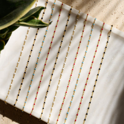 A white tray with a variety of Awe Inspired Colored Enamel Necklaces in gold vermeil on it..
