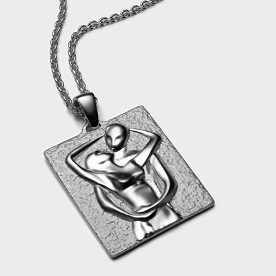 An Awe Inspired Embrace Tablet necklace with a woman hugging a man.