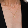 A woman wearing a Flying Dagger Amulet necklace from Awe Inspired with a cross on it.