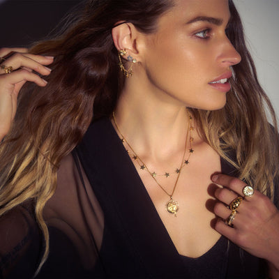 Model wearing a single Sun, Moon & Stars Ear Swag with moonstone cabochon in gold vermeil