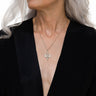 A woman with gray hair wearing an Inverted Torch Amulet necklace from Awe Inspired.