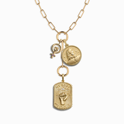 Awe Inspired's Vote Pro-Roe Charm Lariat is a gold necklace with large links, featuring three distinct pendants: a clenched fist, a round coin with a lion, and a Kamala pendant that symbolizes strength and resilience.