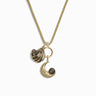 The Sea & Sky Charm Necklace by Awe Inspired is a stunning gold necklace adorned with three unique charms: a shell, a ring, and a crescent moon. Each charm features a small dark pearl, with the crescent moon also showcasing an exquisite Man in the Moon motif.