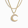 The Awe Inspired Twisted Moon Layering Set features a gold crescent moon pendant with embedded white topaz on a layered gold chain necklace, showcased against a white background.