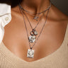 A woman is wearing an Awe Inspired necklace with several pieces on a  Mini Round Amulet Collector Links in sterling silver
