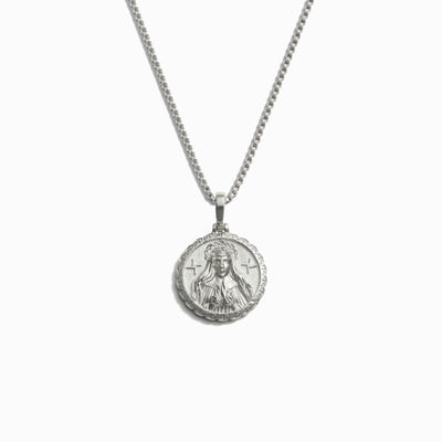 The Mini Brigid Necklace by Awe Inspired is a silver necklace featuring a round triple deity pendant with an engraved depiction of a bearded man.