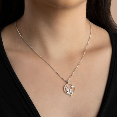 A woman wearing an Awe Inspired Nymph Pendant necklace with a heart shaped pendant.
