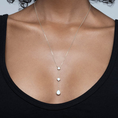 A woman is wearing an Awe Inspired Opal Drop Necklace with opal gemstones in sterling silver
