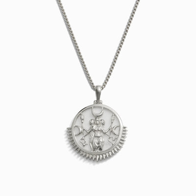 The Special Edition Hecate Necklace by Awe Inspired showcases a silver pendant adorned with an intricate engraving of a multi-armed figure, encircled by ornamental designs that evoke the essence of the Goddess Hecate.