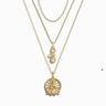 The Seek Enlightenment Necklace Set by Awe Inspired includes three gold necklaces featuring unique pendant designs: an Infinity Snake, a tree motif symbolizing spiritual enlightenment, and a round peacock medallion with hanging pearls.