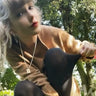 Taylor Swift wearing Awe Inspired Embrace tablet necklace on long chain in gold