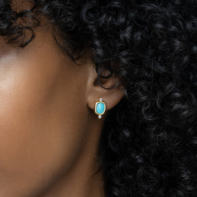 Model wearing a pair of Turquoise Studs in gold vermeil