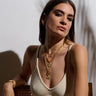 A woman wearing a white top and Awe Inspired's Frigg Pendant.