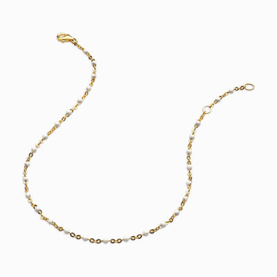 An Awe Inspired gold plated chain with a white and yellow bead.