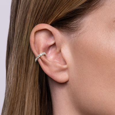 A woman's ear with a White Topaz Ear Cuff in sterling silver by Awe Inspired.