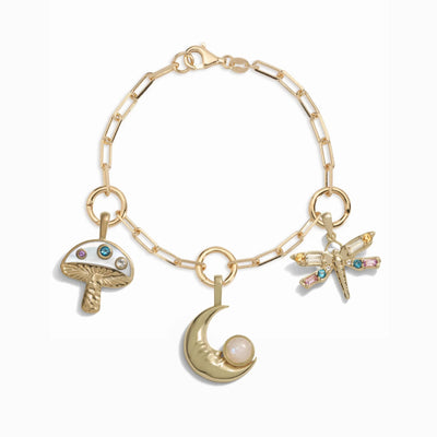 The Earth Magic Charm Bracelet from Awe Inspired showcases a gold mushroom, a crescent moon with a pearl, and a lucky dragonfly.