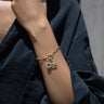 Close-up of a person's wrist wearing an Awe Inspired Invisible Aura Charm Bracelet adorned with two Watchful Moon Eye charms. The person is wearing a dark, long-sleeved top.