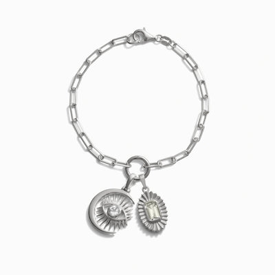 The Invisible Aura Charm Bracelet by Awe Inspired features a chain link design and includes two charms: one shaped like a watchful moon eye and the other shaped like a sunburst with a central stone.