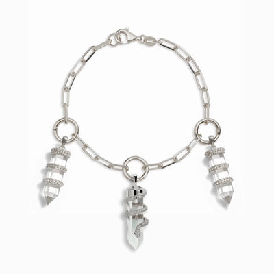 The Guardian's Crystal Charm Bracelet by Awe Inspired is a silver chain bracelet adorned with three large quartz crystal point pendants, each elegantly wrapped with spiral silver accents.