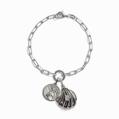 The Ocean Goddess Charm Bracelet by Awe Inspired, a silver chain bracelet with a lobster clasp, featuring a round medallion and a cluster of metal petal-like charms with a pearl accent, radiates beauty and elegance.