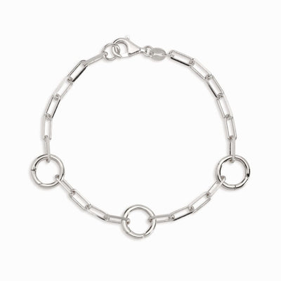 Introducing The Charm Collector Bracelet by Awe Inspired: a silver chain bracelet with three large circular links and a lobster clasp, evoking a 90s charm bracelet aesthetic with 100% repurposed components.