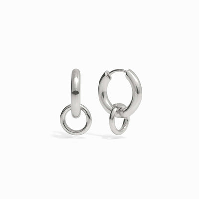 A pair of The Charm Collector Earrings from Awe Inspired, featuring silver classic hoops with a smaller hoop attached to each larger hoop, displayed on a white background.