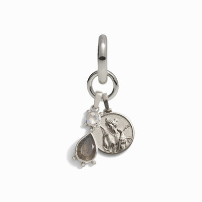 Awe Inspired's Wild Goddess Single Charm Earring is a silver charm featuring a small ring with two dangles: a round disc embossed with the figure of Artemis and a teardrop-shaped gemstone talisman set in a silver prong.