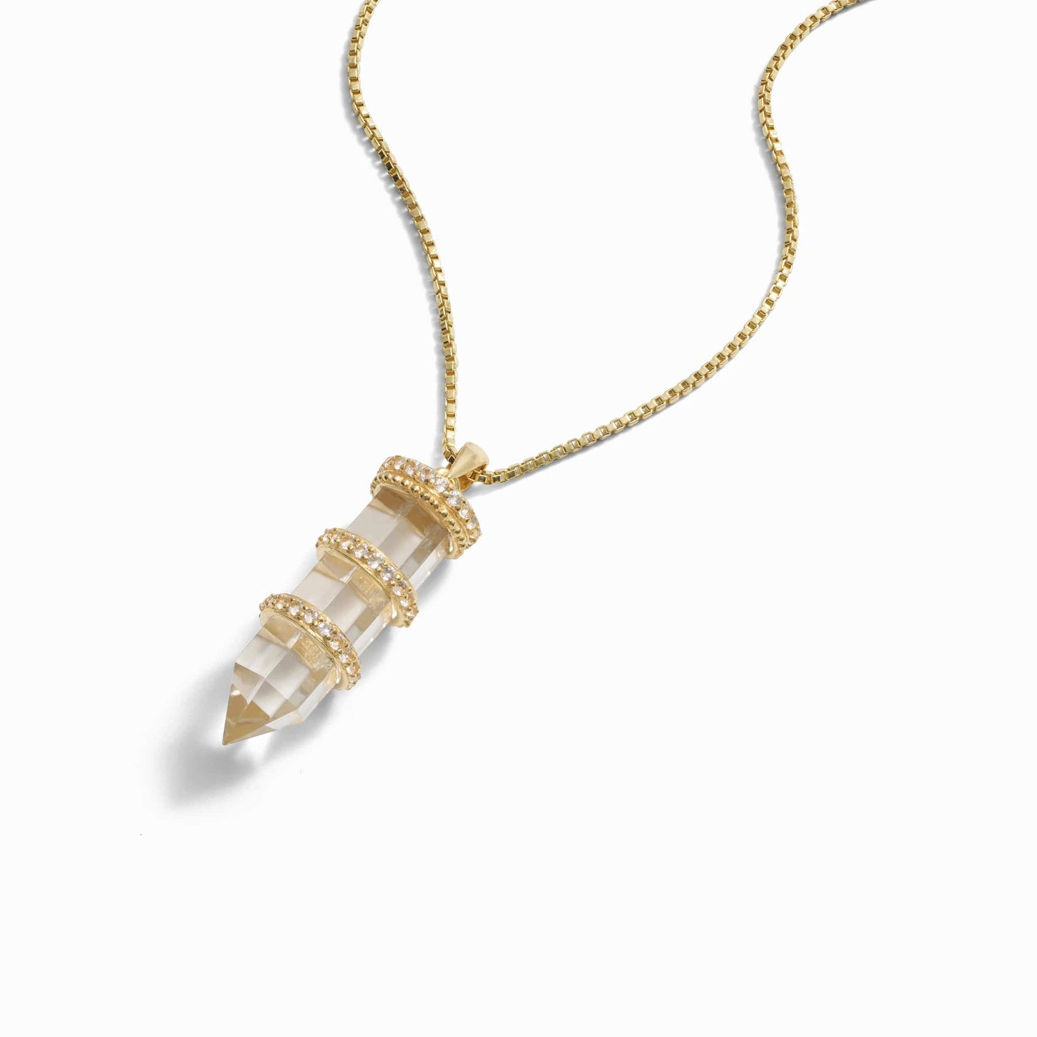 Product image of A gold chain necklace from Awe Inspired, featuring a clear quartz pendant wrapped in three gold bands adorned with small rhinestones, creating the stunning Manifestation Crystal Necklace.