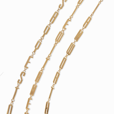 Awe Inspired's Men's Affirmation Necklaces, featuring thin gold chains with small letters spelling out words of personal affirmation, are displayed against a white background.