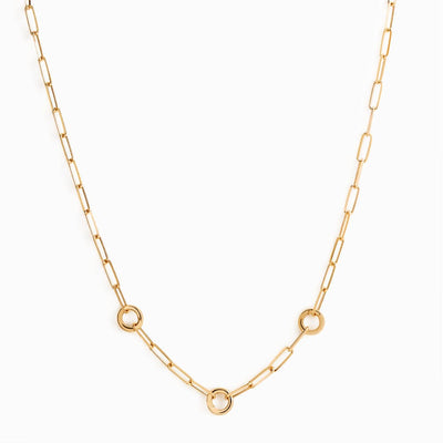 The Convertible Charm Collector Necklace by Awe Inspired is a gold chain necklace featuring rectangular links and three circular accents, designed to hold delicate amulets, evenly spaced along the chain.