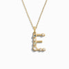 Awe Inspired's Gold Gemstone Initial Necklace features a statement-sized "E" pendant adorned with various small bezel set gemstones.