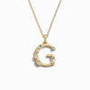 Awe Inspired's Gold Gemstone Initial Necklace features a statement-size pendant shaped like the letter 'G' and adorned with bezel set gemstones.