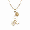 The Lilith Moon Charm Lariat by Awe Inspired features a gold chain with three dangling charms: a round sun charm, a crescent moon with star charm symbolizing the dark side of the moon, and an oval religious medallion. Set against a plain white background, this captivating piece is beautifully presided over by Lilith.