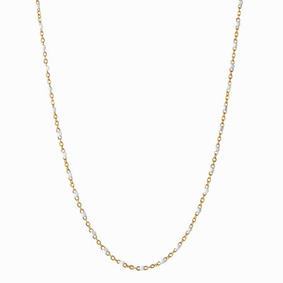 The Chain Necklace by Awe Inspired is a delicate gold chain adorned with small white beads evenly spaced along its length, perfect for elevating your look with elegance.