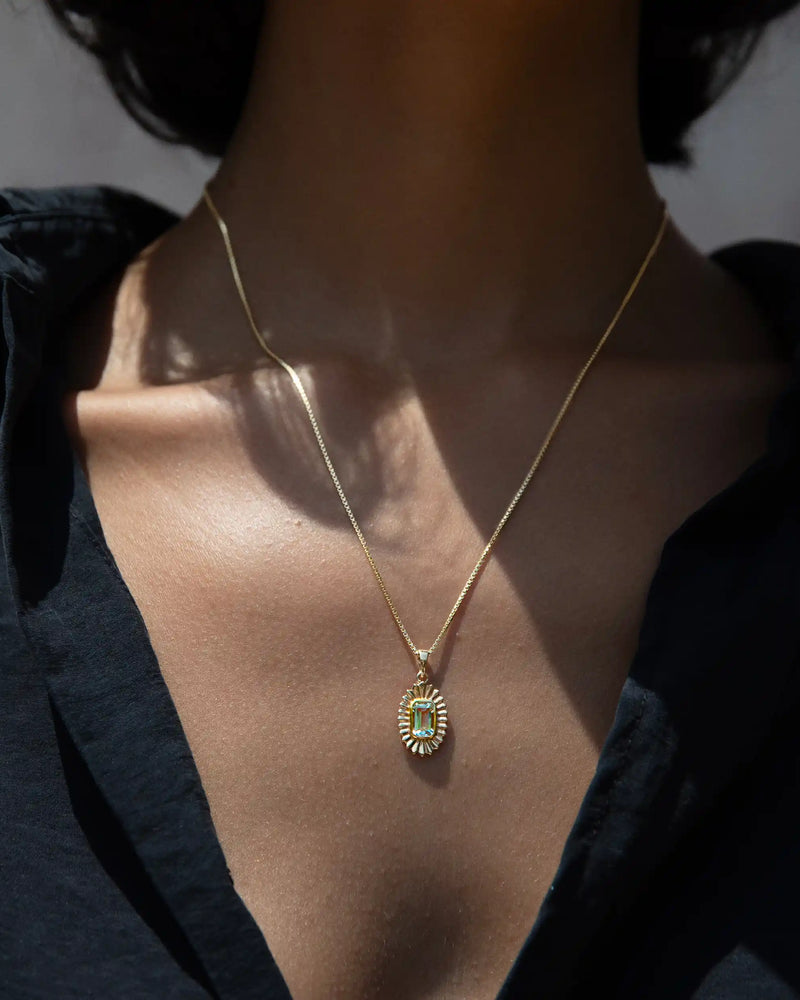 Close-up of a person wearing the Awe Inspired Aura Pendant, exuding an aura of elegance, dressed in a black shirt.