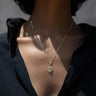 Close-up of a person wearing the Awe Inspired Aura Pendant, exuding an aura of elegance, dressed in a black shirt.