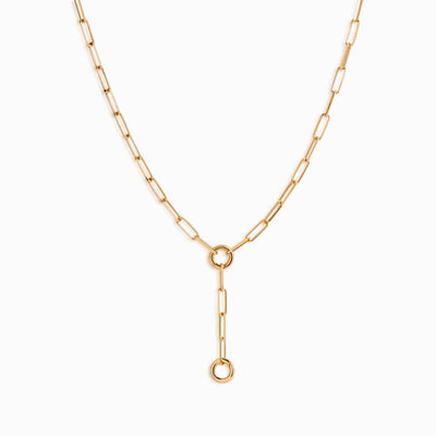 The Convertible Charm Collector Necklace by Awe Inspired features a gold chain with rectangular links and a vertical extension ending in a circular loop, ideal for pairing with goddess pendants or amulets.