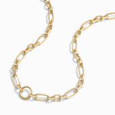 A close-up of a wide luxe link chain necklace with oval links and a small circular pendant. The Statement Single Charm Collector Necklace by Awe Inspired is elegantly laid out in a curved pattern against a plain white background.