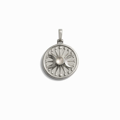 Awe Inspired's "The Storm Before the Calm Charm Necklace" features a silver circular pendant with a central pearl and symmetrical radial design, reminiscent of the divine feminine essence, much like a Triple Moon pendant adored by Alanis Morissette.