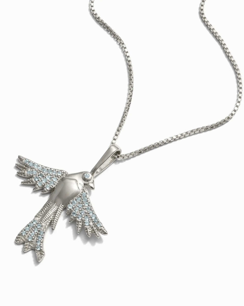 Suffragist Bluebird Necklace by Awe Inspired featuring a bluebird-shaped pendant with blue topaz accents on a silver chain, displayed against a white background.