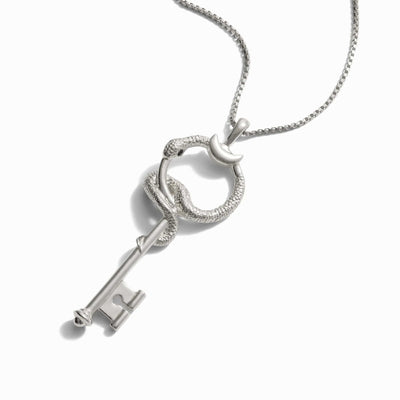 Close-up of a silver necklace featuring a key pendant entwined by a snake with a crescent moon detail, evoking the hidden power of an **Awe Inspired The Gate of Hades Key Necklace**.