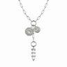 The Manifestation Lariat Charm Necklace by Awe Inspired is a silver lariat necklace with a chain-link design, featuring two coin-like pendants inscribed with "Everything I Need Is Within Me" and a crystal pendant at the center.